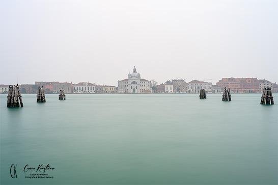 Kirche in Venedig mit Meer im Vordergrund.